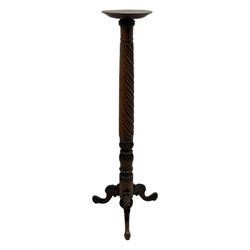 Late 19th century mahogany torchère stand, with circular top above a twisted and foliate carved collumn, on a scroll carved tripod base, on cabriole legs