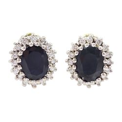 Pair of 14ct white gold oval cut sapphire and round brilliant cut diamond cluster stud earrings, total sapphire weight approx 3.55 carat, total diamond weight approx 0.30 carat