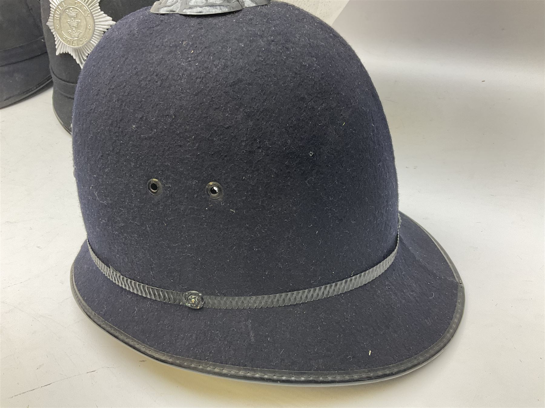 Hull City Police - helmet with king's crown night plate; two further ball-top helmets with Queen's crown plates; and a peaked cap (4)