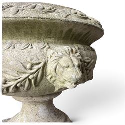 Regency design weathered cast stone garden urn of kylix form, the anthemion and arrowhead moulded everted rim over a fruiting laurel and lion-mask relief decorated body, waisted socle on square base, stamped HGC