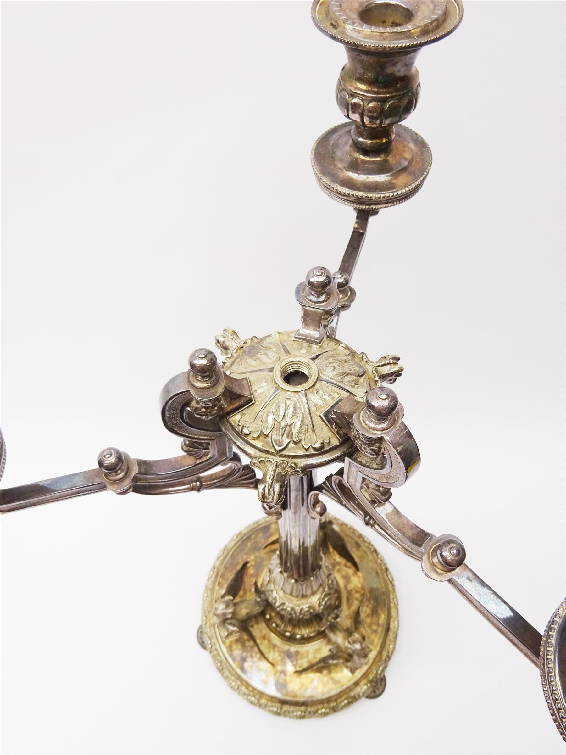 A large Victorian Thomas Bradbury & Sons silver plated candelabrum, the circular base with flower head border upon three domed feet, supporting a central knopped and fluted column flanked by three zoomorphic creatures, leading to a central socket with removable nozzle above a large palmette detailed drip pan, and three scrolling branches with conforming sockets and nozzles, with maker's silver plate mark and Victorian registration lozenge beneath, H62.5cm