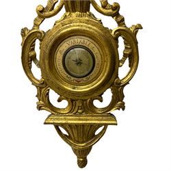 A 20th century Italian barometer in a carved gilt wood case in the late 18th century rococo style, with an English aneroid movement, steel indicating hand and contrasting recording hand, with weather predictions.
