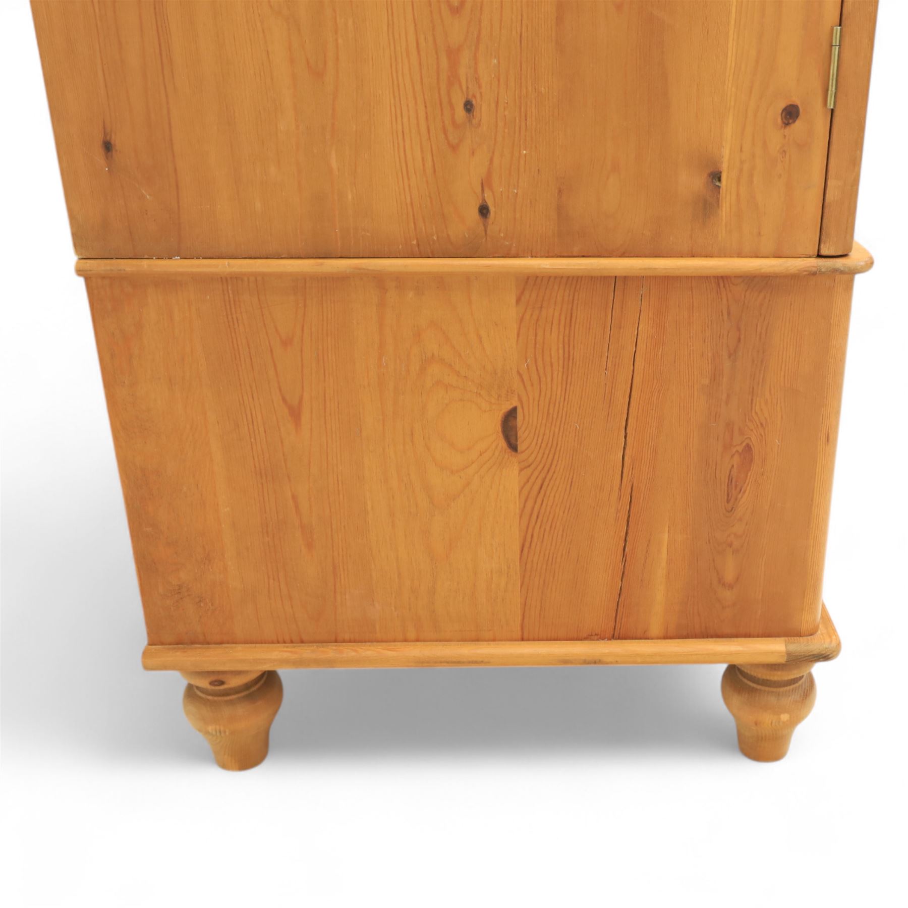 Two contemporary traditional-style wardrobes, projecting plain cornice above two arched moulded panel doors, above a full-width drawer fitted with turned wooden handles, raised on turned bun feet