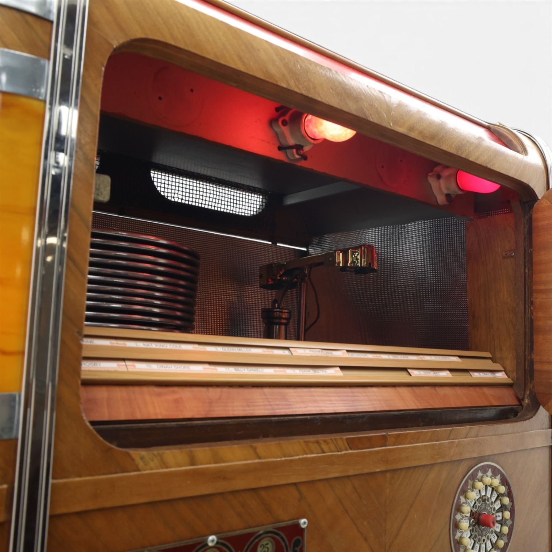 Rudolf Wurlitzer Company - Model 616 'Simplex' 1937 jukebox, figured walnut veneered cabinet with illuminated red and amber side panels enclosed by chromed uprights, glazed upper record compartment, cast Art Deco speaker grille, coin-operated push-button selection panel with circular title index, raised on a moulded base