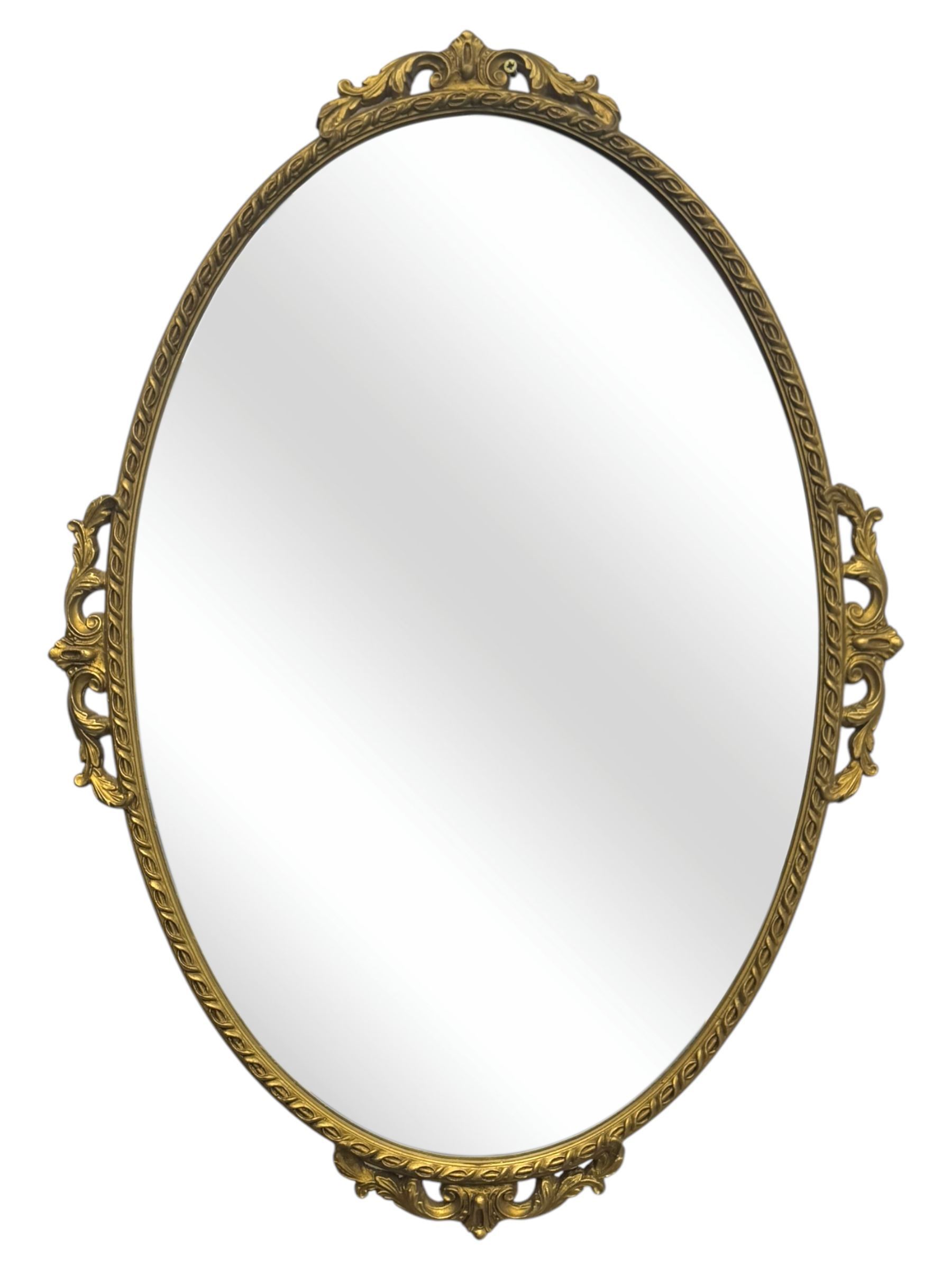 Oval gilt wall mirror, with bevelled edge plate within a moulded frame cast with acanthus scrolls and foliate decoration, pierced cartouche crest and apron, flanked by scrollwork handles