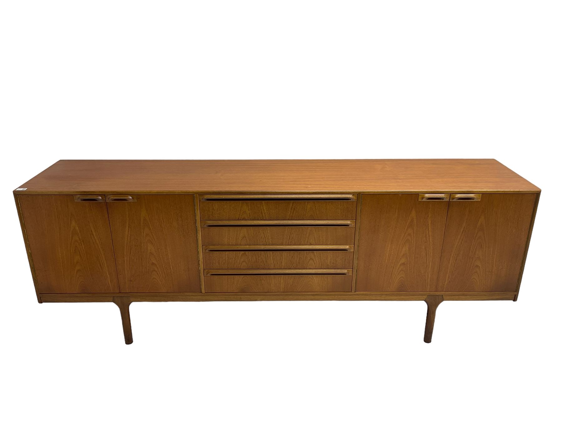 Tom Robertson for AH McIntosh & Co of Kirkaldy - mid-20th century teak sideboard, fitted with four central drawers, flanked by cupboard enclosing shelves and sliding tray, raised on cylindrical supports