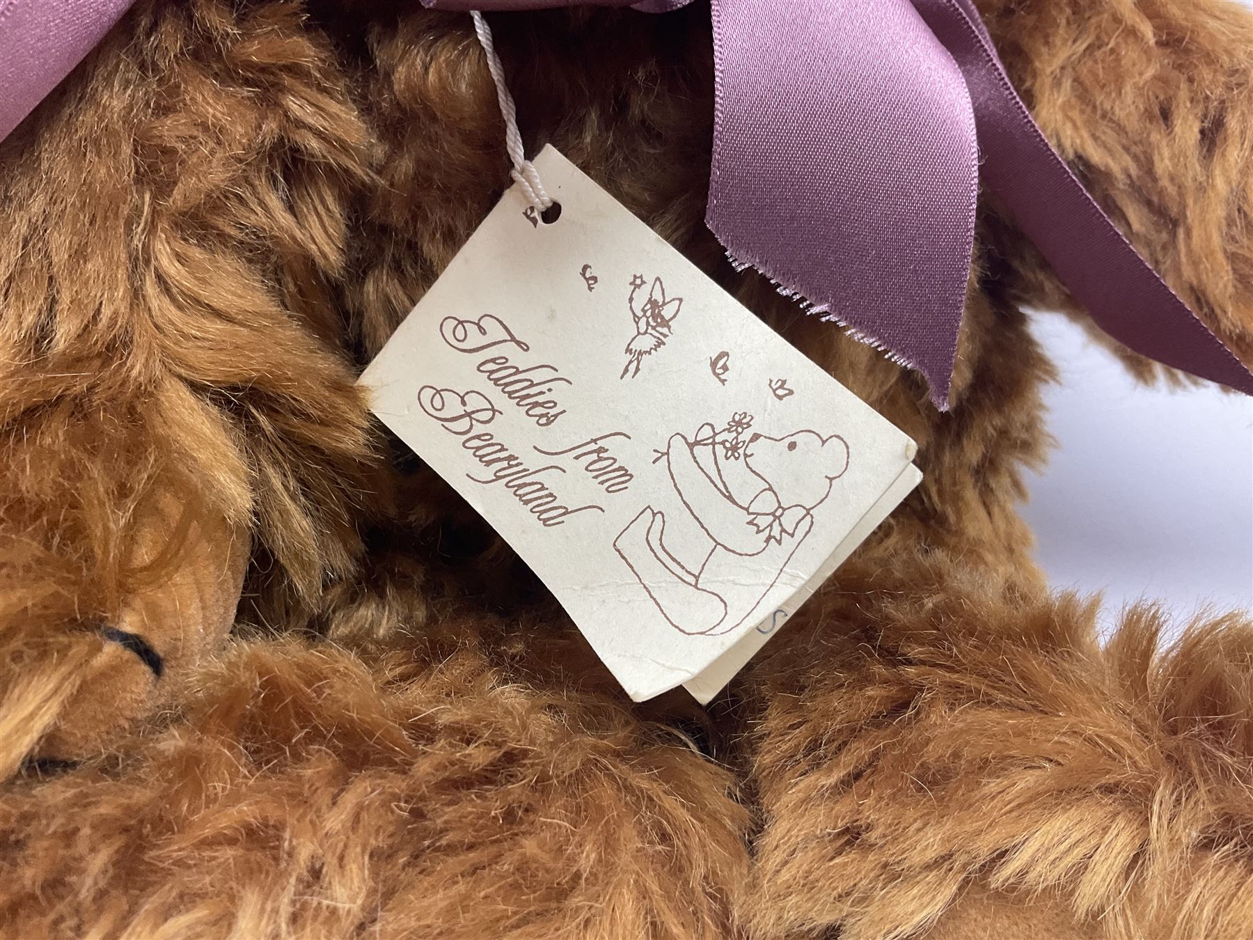 Group of five teddy bears comprising ‘George’ a unique pellet filled bear with glass eyes and velvet paws H38cm, and ‘Abbey’ a luxury German plush with wobble head and glass eyes no.5/10 H24cm, both with Teddies from Bearyland labels; along with two light blonde mohair H. M. Bears and Boyds Bears ‘T. F. Wuzzies’ no. 595140 (5)