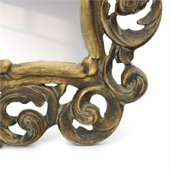Rococo style gilt wall mirror, the shaped rectangular bevelled plate within a pierced frame of scrolling acanthus leaves, surmounted by a foliate crest