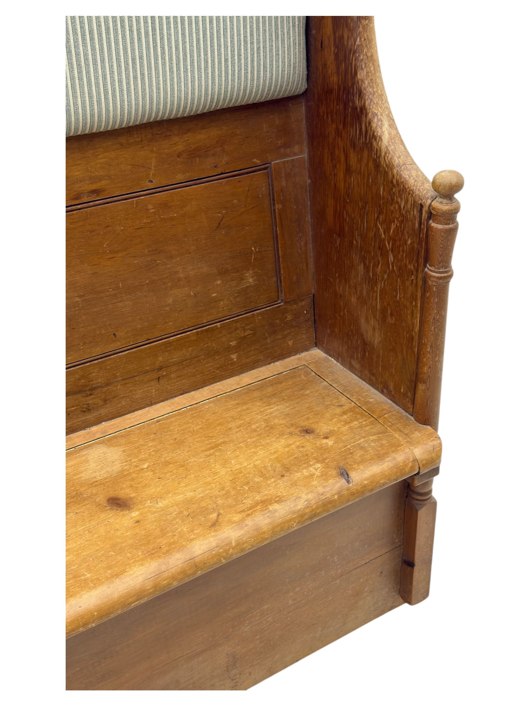 Early 20th century waxed pine pew, inset upholstered striped back panel with hinged box seat enclosing storage, shaped arms and turned supports