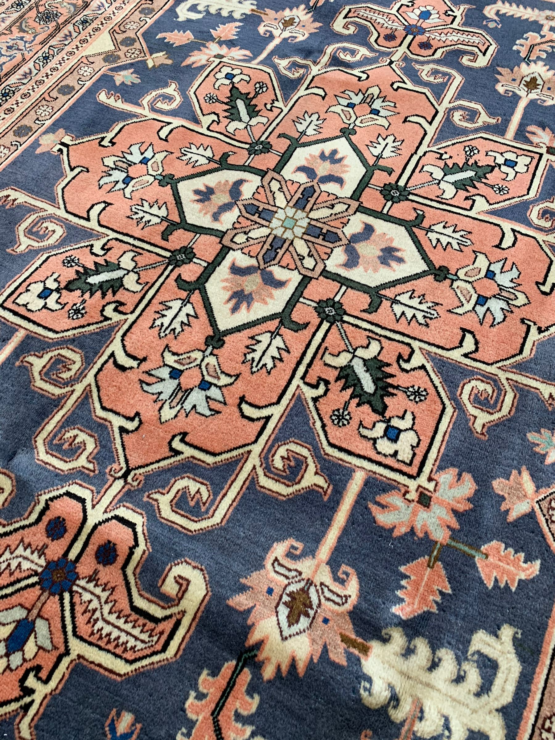 Persian ivory and peach ground, overall geometric design, the field with central star medallion surround stylised leaf motifs, guarded geometric design border