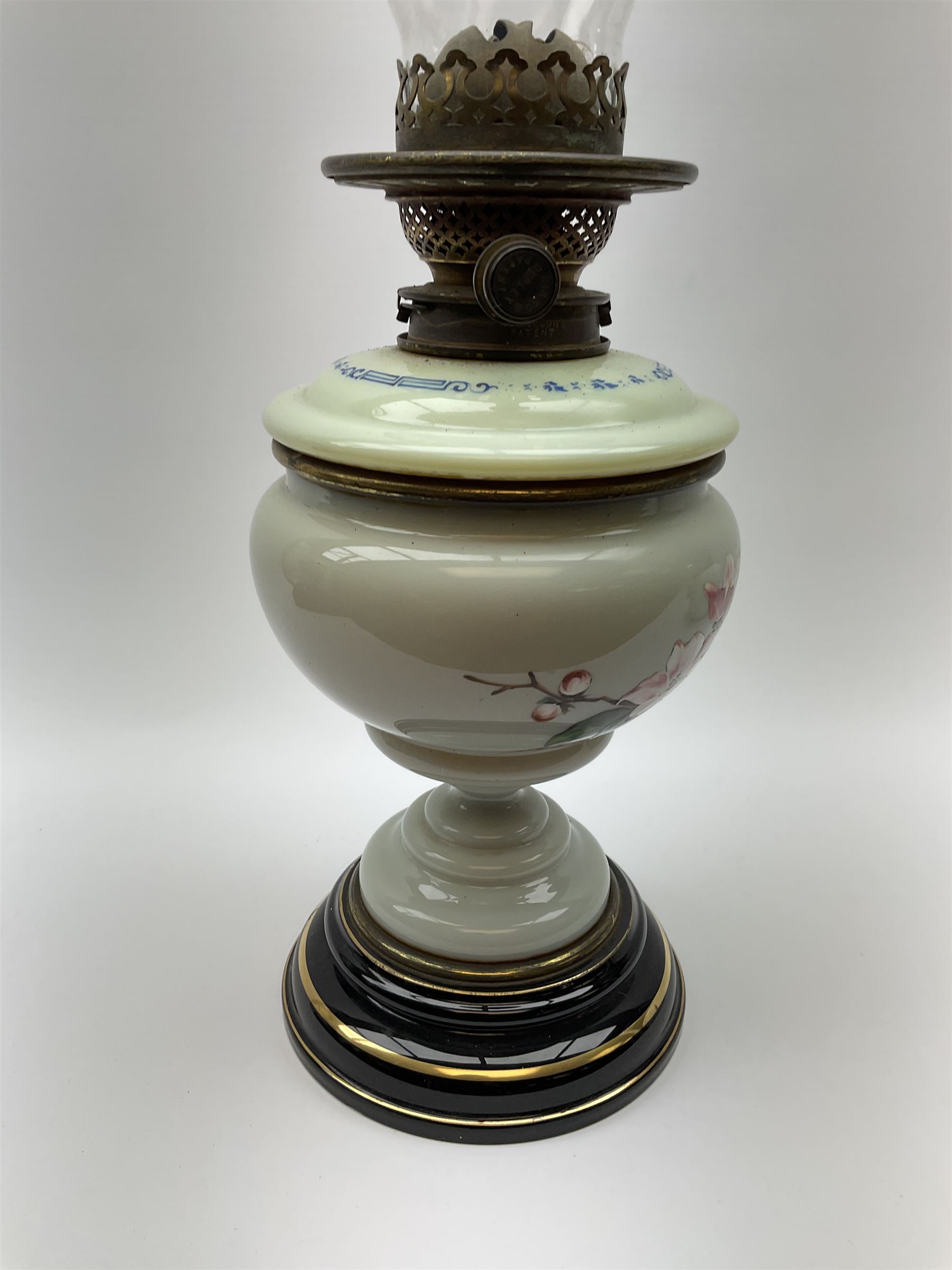 A Victorian oil lamp, with opaque glass reservoir hand painted with flowers beneath a Hinks burner and supporting a globular floral painted opaque glass shade and glass chimney, H47.5cm. 