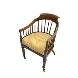 William IV rosewood tub armchair, the arched bow cresting rail over graduated bobbin turned spindles, cane seat with loose cushion, terminating in brass cups and castors.