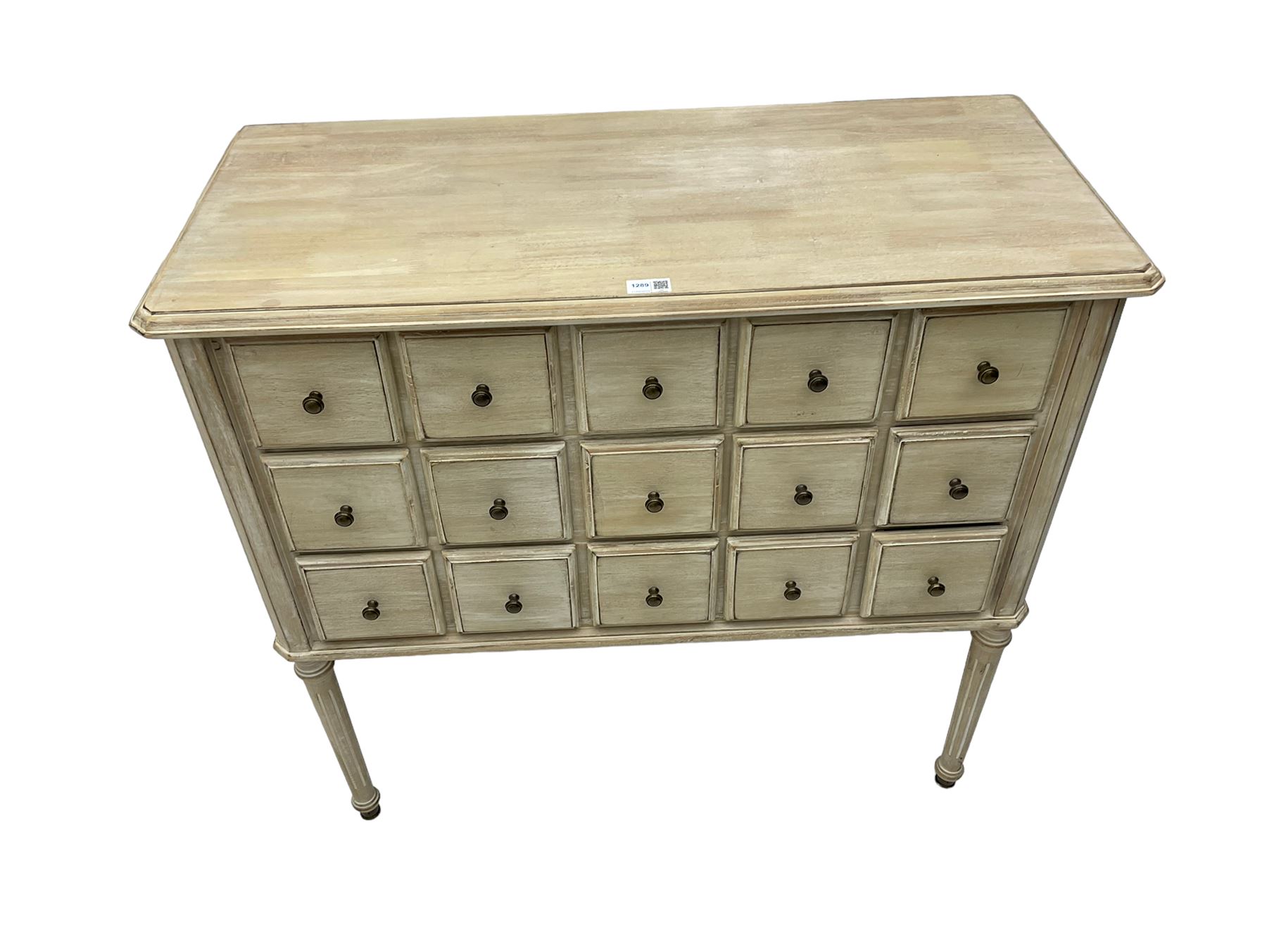 Washed finish pigeon hole or apothecary style chest, fitted with fifteen drawers, raised on fluted tapered supports 