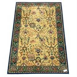 Persian design rug, pale gold ground field decorated with trailing branch and stylised floral motifs, the border decorated with flower heads
