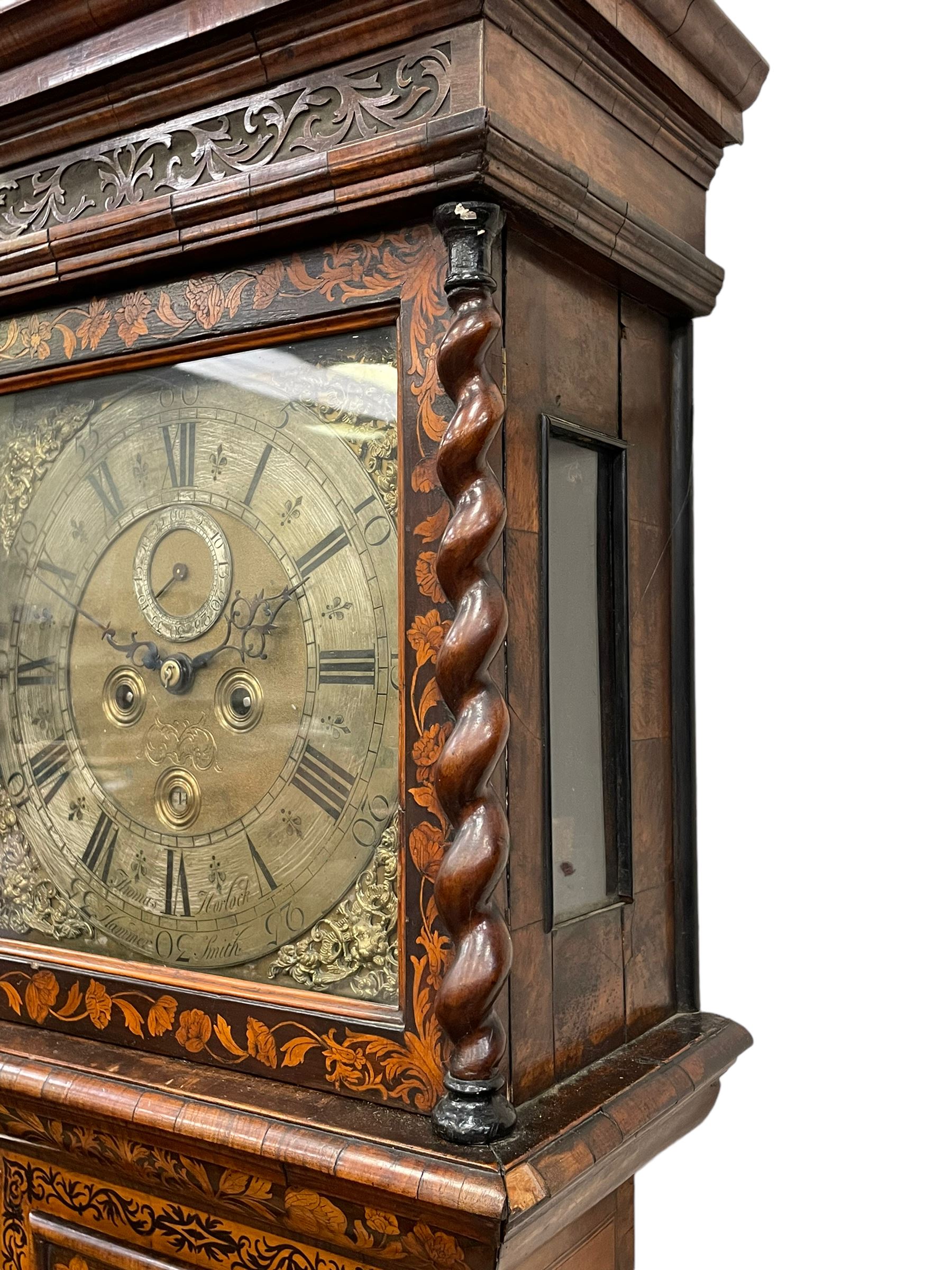 William & Mary floral marquetry 8-day longcase clock c 1700, later mid-18th century four pillar rack striking movement with a square brass dial and subsidiary seconds dial, ringed winding holes and calendar aperture to the matted dial centre, with London cherub head cast spandrels and (later) fretted steel hands, silvered Roman numeral chapter ring with stylised fleur di Lis half hour makers, narrow Arabic five-minutes, minute track and inner quarter hour track, signed Thomas Horlock, Hammersmith, 
case with box upstand to the domed floral marquetry decorated caddy with three brass flame finials, above a moulded cornice and fretwork frieze,  inlaid hood door with attached barley twist pillars to the front above an inlaid convex moulding, full length D moulded trunk door with a circular lenticle inlaid with floral and foliage panels inhabited with birds, on a conforming marquetry plinth with applied double skirting. Thomas Horlock is recorded as a Whitesmith & Clockmaker of Hammersmith, Middlesex.
A copy of Thomas Horlock's will dated the 15th June 1757 is held at The National  Archives Kew.