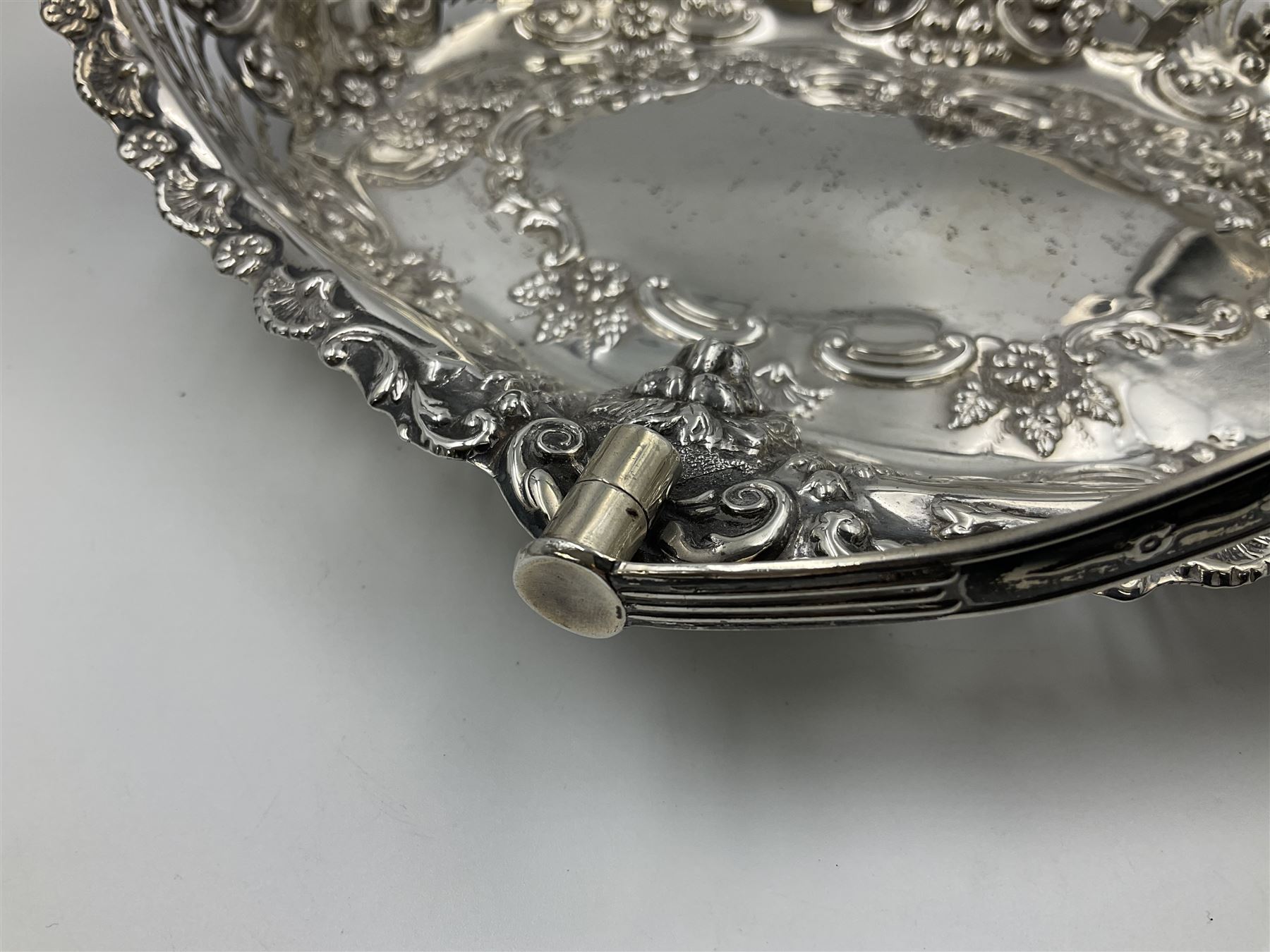 Edwardian silver swing handled basket, of navette form, with four repousse lion masks to each corner and with pierced and embossed floral, scroll and shell decoration to sides, base and handle, hallmarked Charles Horner, Birmingham 1906, height including handle H20cm