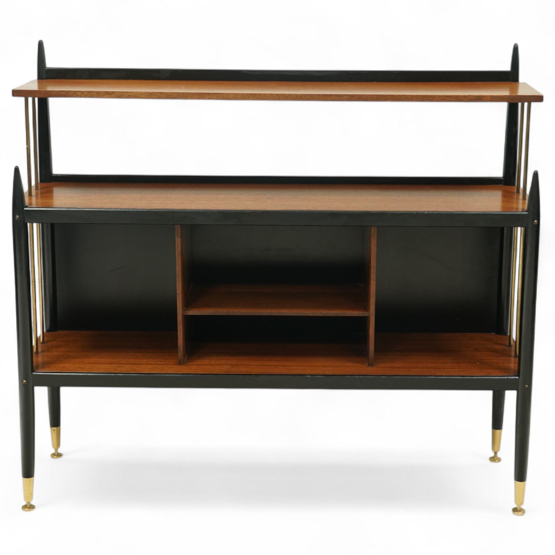 E Gomme for G Plan - 'Librenza' mid-20th century teak and ebonized wood bookcase, rectangular three-tier open shelf design with finials, narrow and raised top shelf above full span and depth central shelf, above divided shelf with open pigeonholes, sides with brass rods, raised on tapering legs with brass capped feet