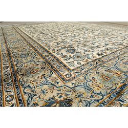 Central Persian Kashan hand-knotted carpet, ivory field profusely decorated with an all-over scrolling vine, palmette, and lotus design in shades of soft blue, pale gold, and green within floral borders
