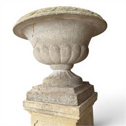 Weathered cast stone statue of a child and urn planter on pedestal along with three piece bird bath