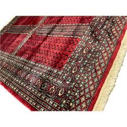 Tekke Ensi crimson ground rug, the quartered field decorated with candelabra motifs, multi-guarded border with repeating geometric hexagonal lozenges in blue and ivory