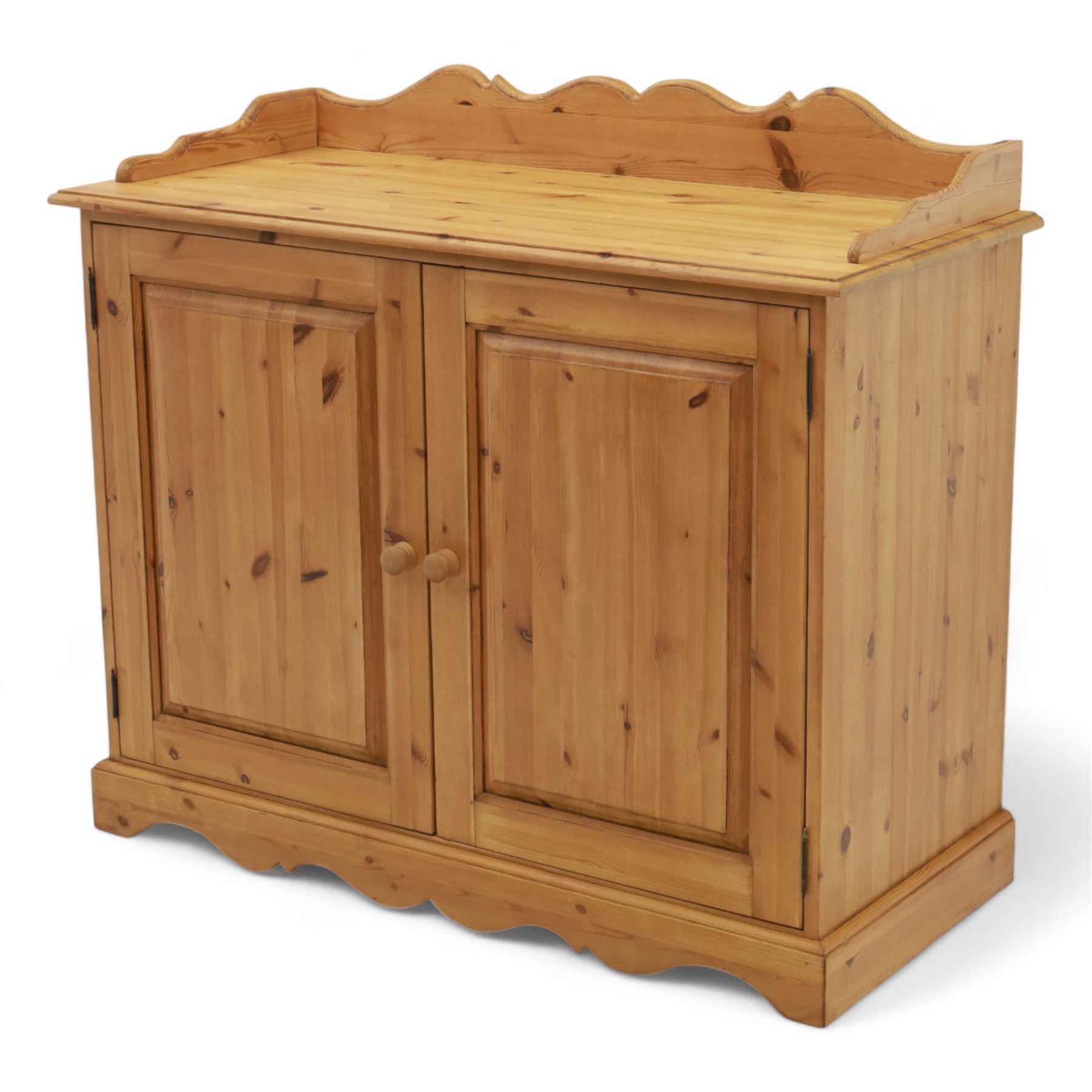 Contemporary pine cupboard, with raised shaped gallery over plain top, panelled double doors below with turned knob handles, shaped apron and plinth base
