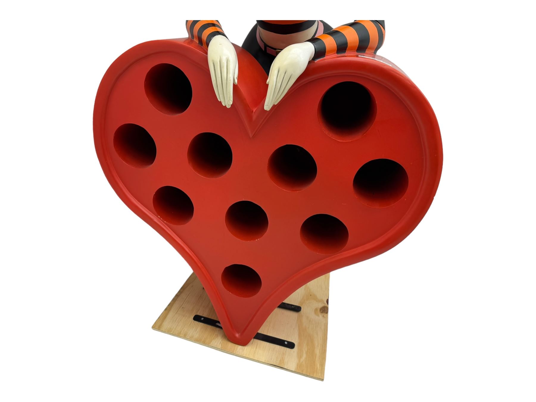 Contemporary large-scale Betty Boop painted wine rack, modelled leaning against a heart-shaped stand with ten circular bottle slots, dressed in black and orange striped attire