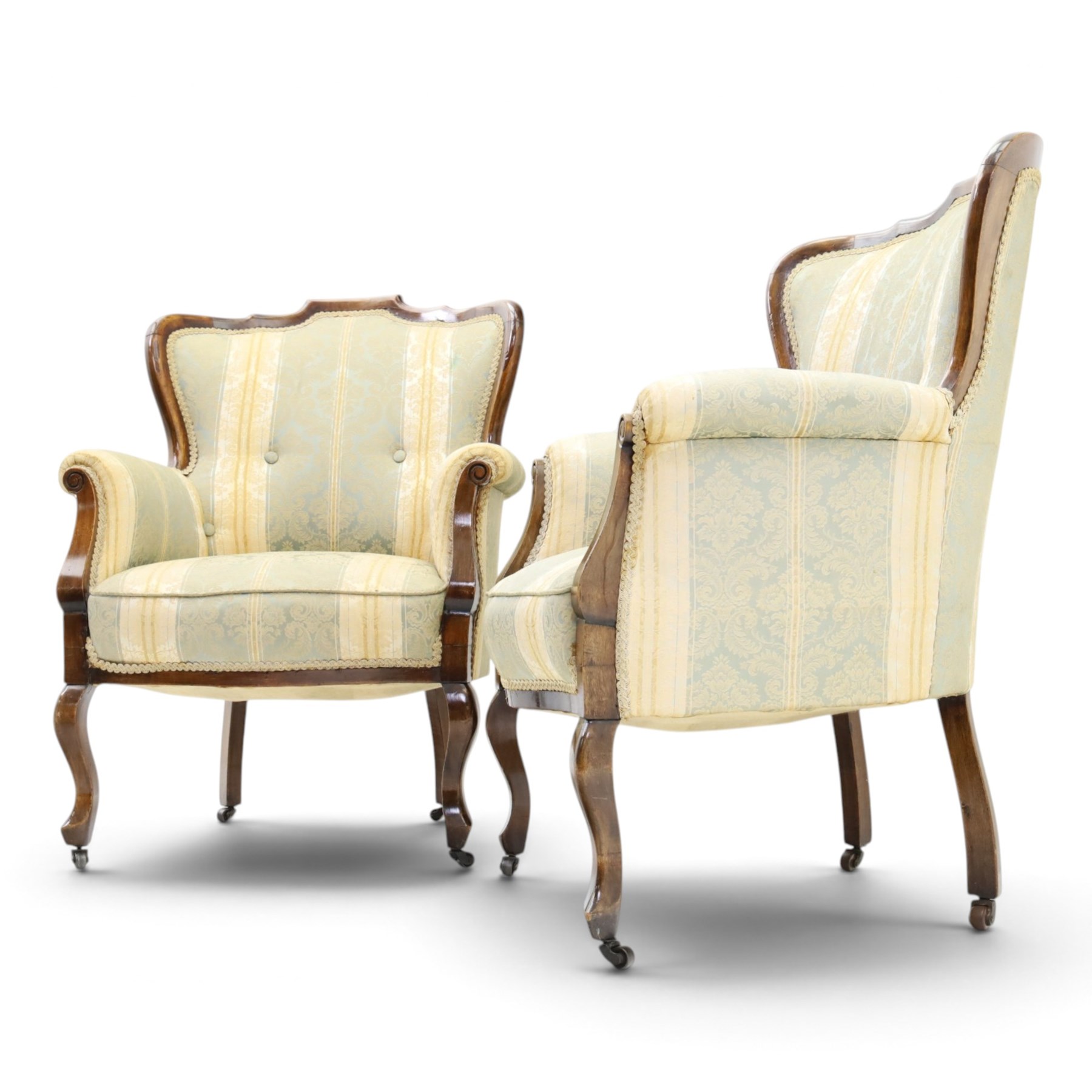Edwardian mahogany three-piece salon suite, comprising settee and two armchairs, shaped frames with upholstered backs, scrolled arm supports and serpentine seat rails, upholstered in striped floral damask fabric, on cabriole supports with castors (Armchairs: H 96cm, W 70cm, D 68cm)