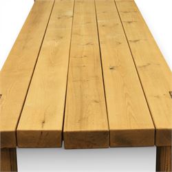 Modern large oak plank top dining table and twelve brown leather high back chairs, table of rustic construction five solid planks with exposed supports, the chairs in brown leather hide with ten standard height and a pair of taller chairs for the foot and head of the table