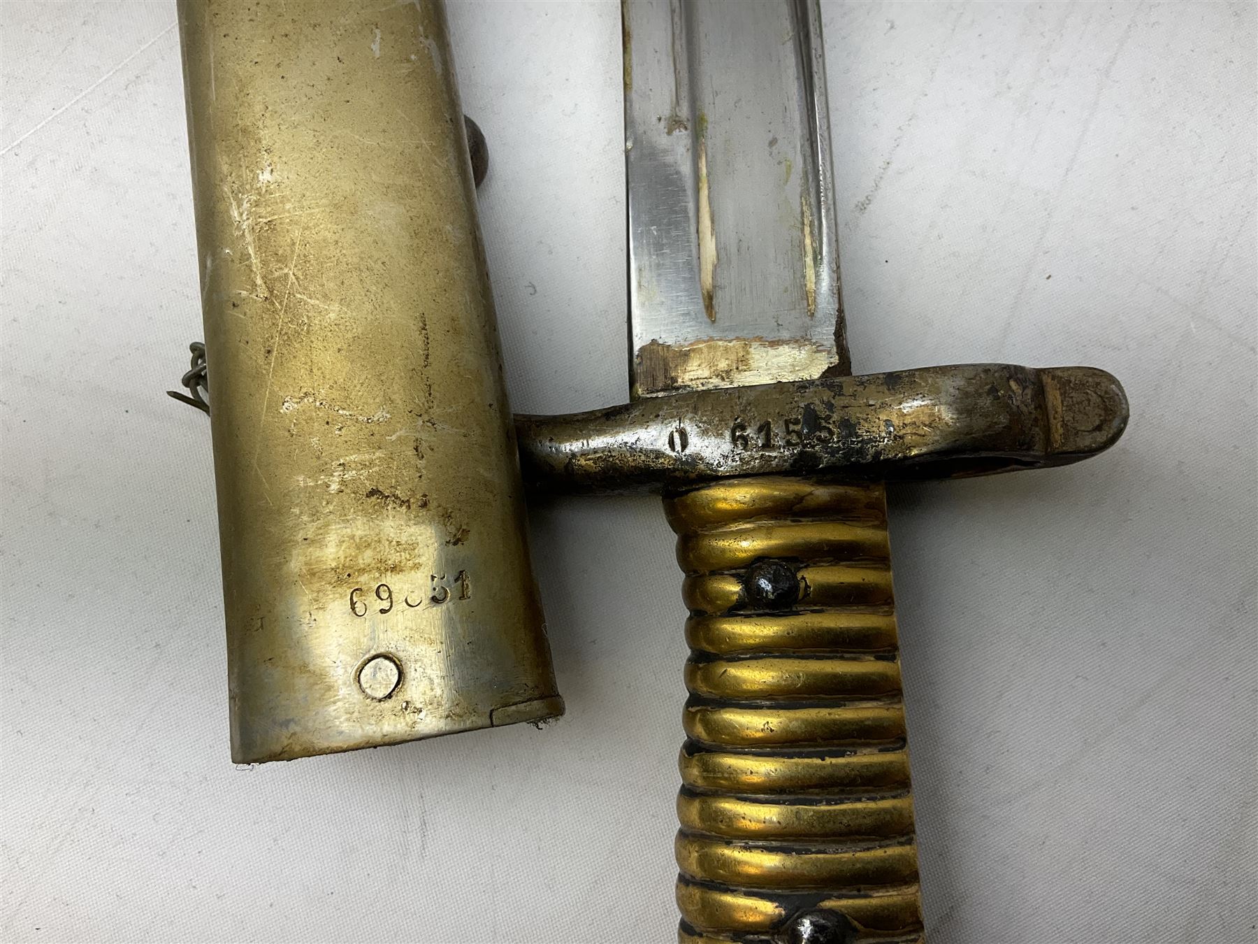 French Model 1866 sabre bayonet with 57cm fullered steel curving blade; in steel scabbard L71cm overall; another Model 1866 sabre bayonet lacking scabbard; and British Pattern 1856 sword bayonet (no scabbard) (3)