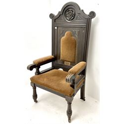 Late 19th century oak throne chair, shaped cresting rail with carved Yorkshire Rose, upholstered splat, arms and seat, turned supports on castors 