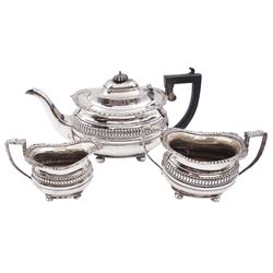 Early 20th century Edwardian silver three piece tea service, comprising teapot, open sucrier and milk jug, each of bellied form with oblique gadrooned rim, the teapot with black plastic finial and handle, upon four bun feet, hallmarked George Nathan and Ridley Hayes, Chester 1911 and 1913, teapot H15.4cm