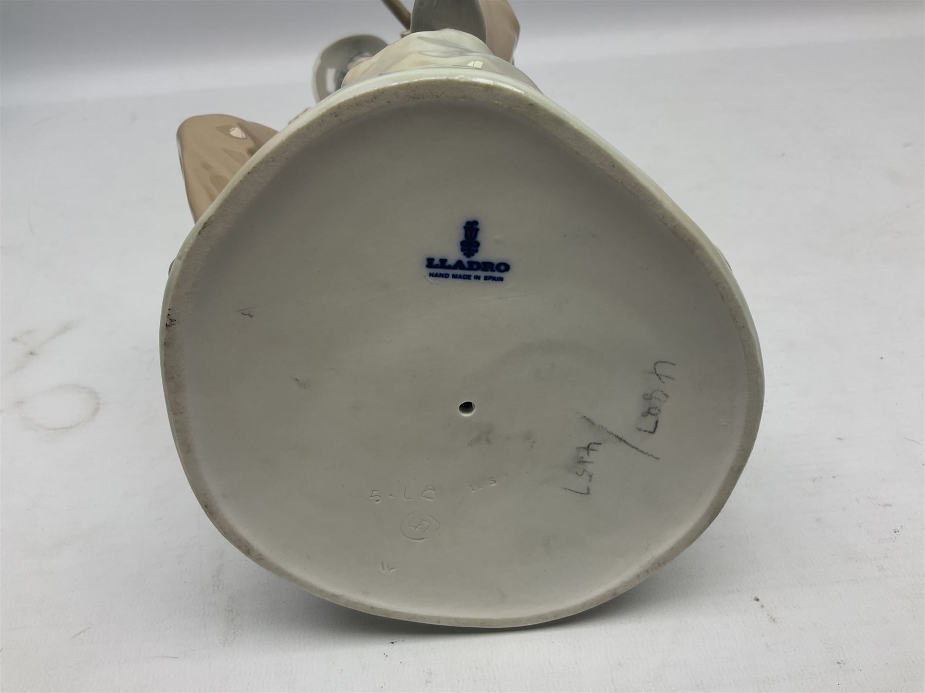 Lladro figure, Violinist, modelled as a man seated upon a  mile stone holding a violin, sculpted by Salvador Furió, no 4887,  year issued 1984, year retired 1981, H35cm