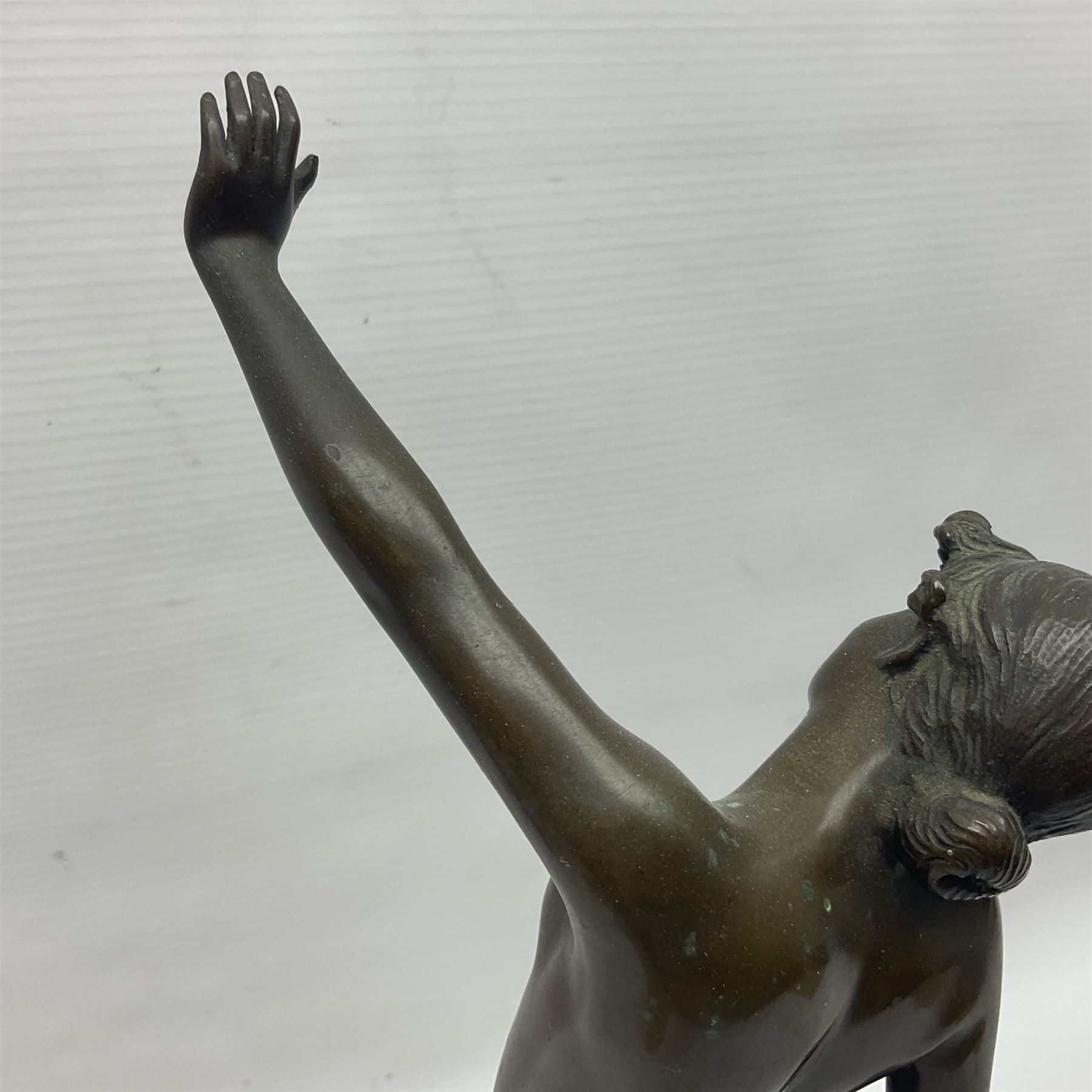 Bronzed semi nude female figure with one hand raised, upon a marble plinth, H43cm  