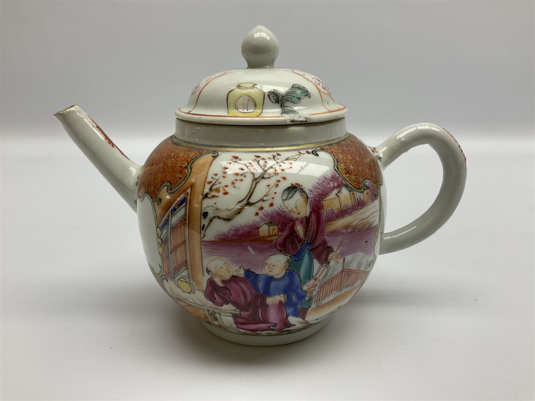 Two late 18th/early 19th century Chinese export teapots, the largest example of globular form with curved handle and straight spout, decorated in the Mandarin style with figural scenes surrounded by red scale reserves, H13.5cm, the second smaller example decorated in underglaze blue with two musicians in a landscape set with willow tree and fence, H10.5cm

