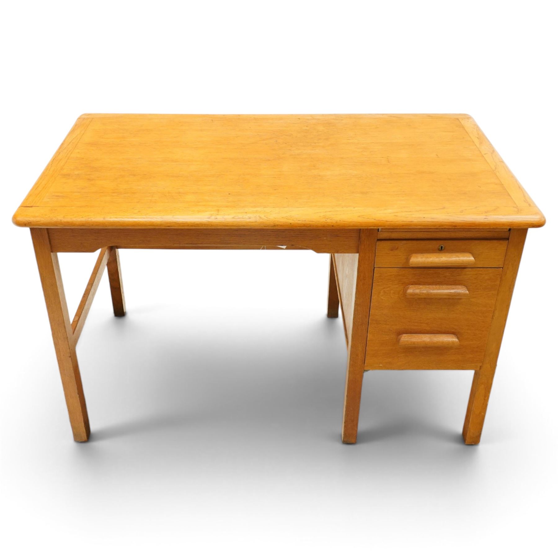 Abbess Woodwork Company - Mid  20th century solid oak single pedestal desk, rounded rectangular top with single pedestal, oak pull handles with fitted slide, above a drawer with cutlery divider, over a double height drawer, square tapering supports united by stretchers