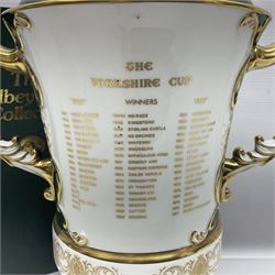 Aynsley twin handled racing cup and cover, to commemorate 'The Golden Jubilee of the Revival of The Yorkshire Cup', the handles inscribed '1927' and '1977', the green body painted by E. Woodhouse with Joe Childs up on Trimdon, the reverse with the winners, the domed cover with a Yorkshire rose finial, limited edition no. 4 of 50, on hexagonal wooden base with certificate, H34cm