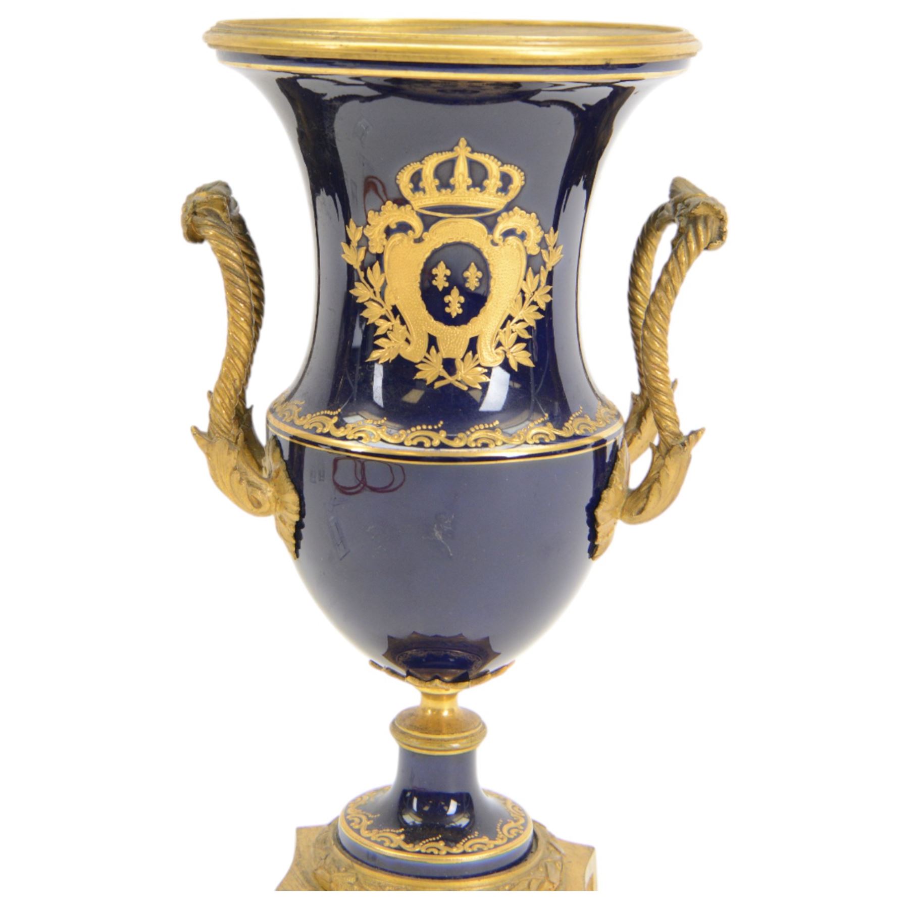 19th century Sevres style ormolu mounted porcelain twin handled urn, the body decorated with a gilt crowned crest of three fleur de lis against a cobalt ground, with spurious Sevres mark beneath, H26cm
