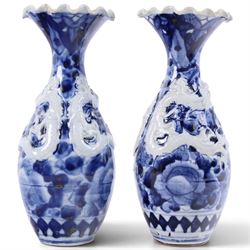 Pair of blue and white moulded vases, decorated with dragons amongst clouds, together with two blue and white planters painted, the first decorated with pagodas within a landscape scene, the other with musicians, vases H26cm 