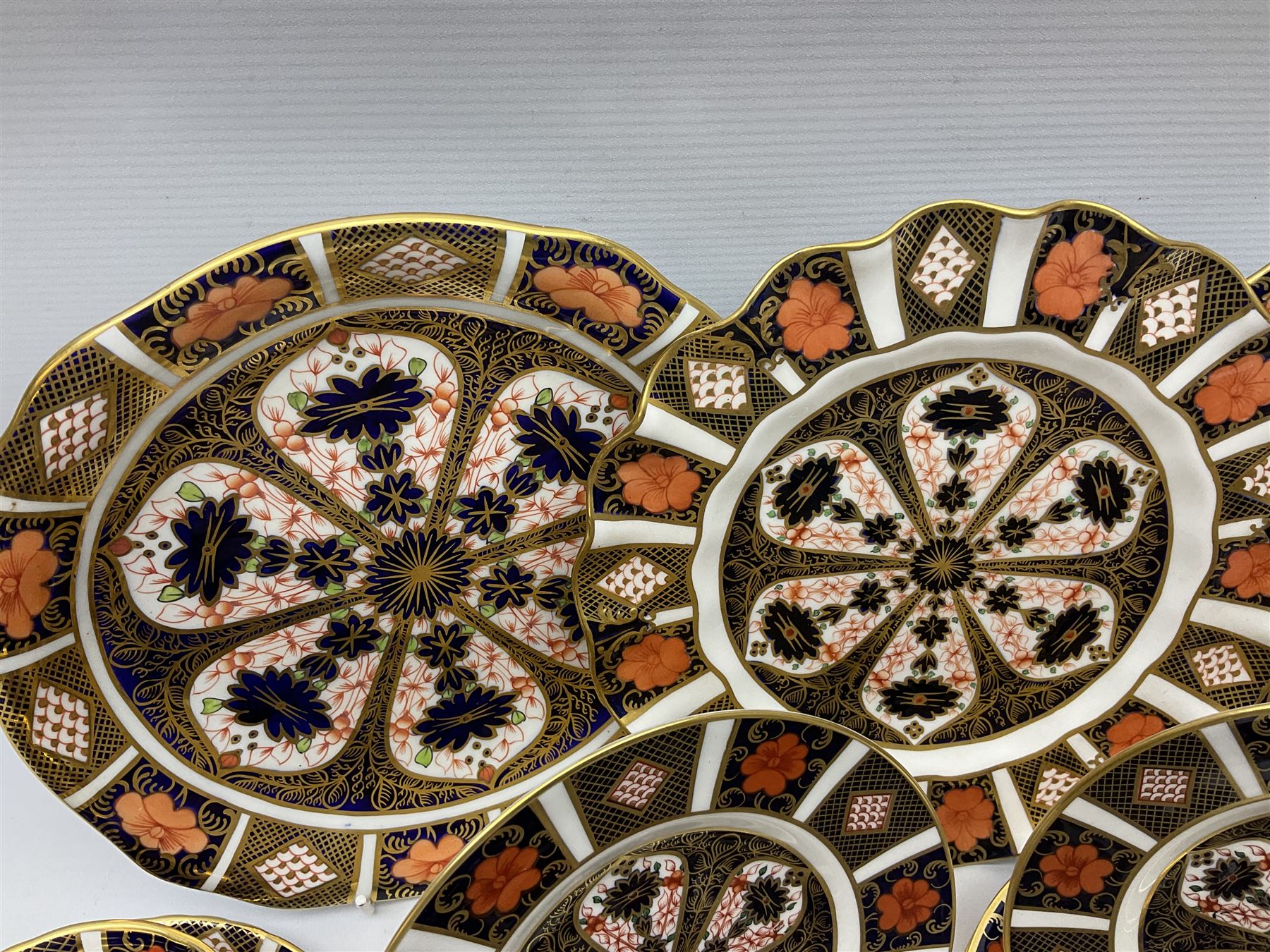 20th century Royal Crown Derby Imari 1128 pattern tea wares, comprising six teacups, five saucers, five side plates, a pair of serving plates, and one other with wavy rim, each with printed marks beneath including various year cyphers, side plates D16cm serving plates each approximately D22cm