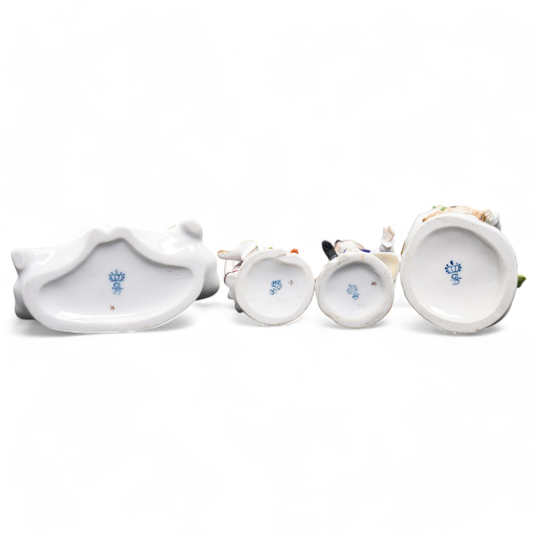 Group of Sitzendorf porcelain figures, one modelled as two children with birds and lambs, the others holding and offering flowers, each upon gilt detailed base, with painted marks beneath (4)