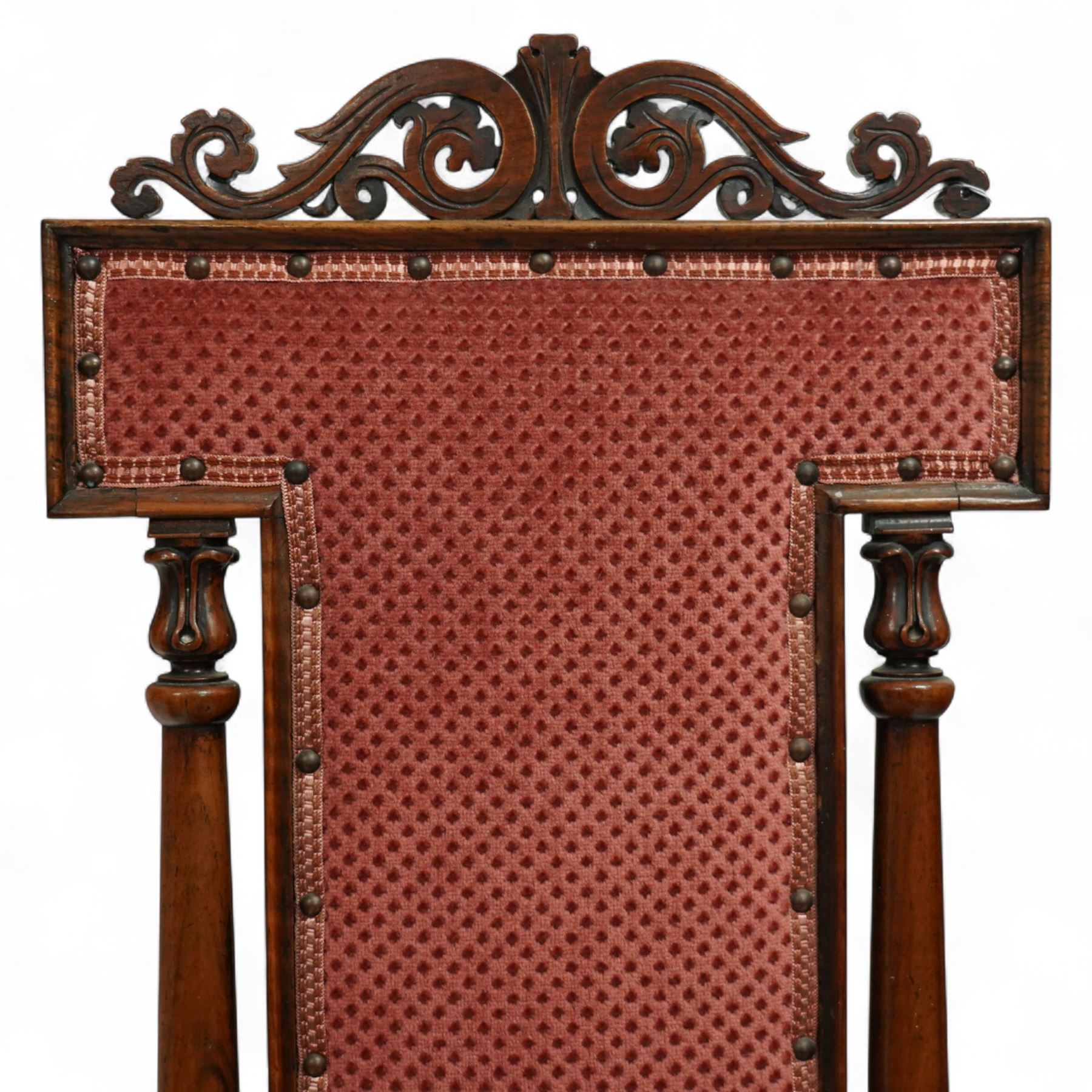 Victorian walnut high back hall chair, with pierced and scrolled crested rail above a rectangular back and seat upholstered in plush cerise fabric, flanked by tulip carved and turned uprights raised on turned and tapered front legs  