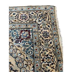Persian Kashan ivory ground rug, central medallion surrounded by scrolling leafy branches and stylised flowerhead motifs, scrolling border decorated with further stylised plant motifs