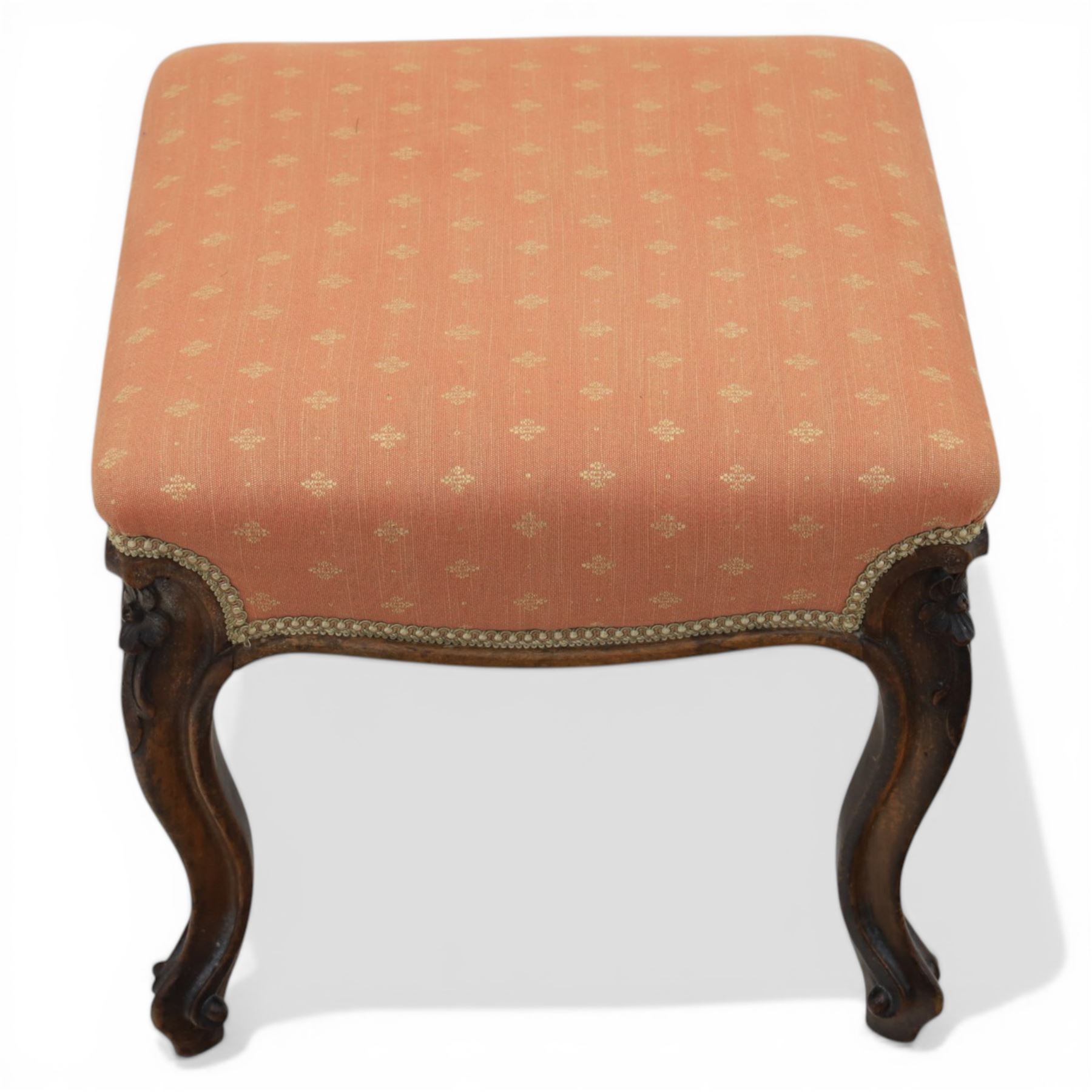 19th century mahogany framed footstool on floral carved cabriole supports upholstered in coral fabric