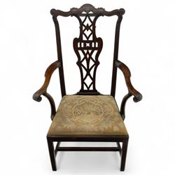 19th-century Chippendale Revival design mahogany oversized high-back armchair, serpentine crest carved top rail above pierced back splat with interlaced ribbon carving and geometric fretwork design, and outward scrolling arms above drop-in needlework seat on square chamfered legs 