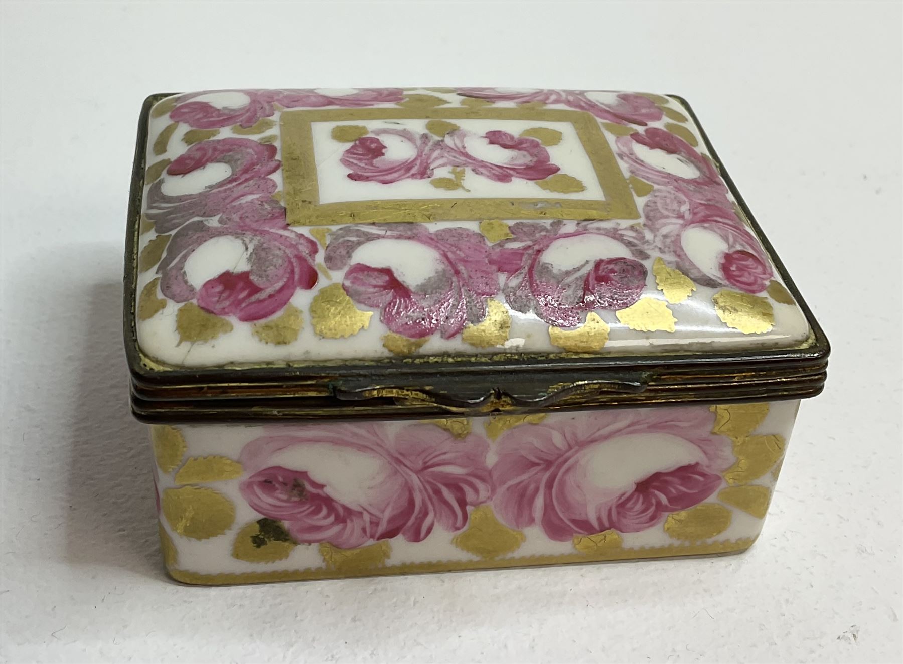 Early 19th century Swansea box of rectangular form, densely decorated with painted pink cabbage roses and gilt foliage upon plain ground, the hinged lid opening to reveal interior painted with two further roses upon plain ground, marked Swansea. in gilded lettering beneath, W7cm H3.5cm D5.5cm