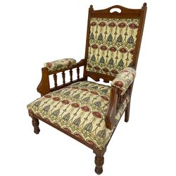 Early 20th century armchair, back and sprung seat upholstered in Art Nouveau patterned fabric, raised on ring turned supports, the frame with all-over reeded decoration