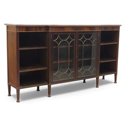 Early 20th century mahogany breakfront bookcase cabinet, the moulded rectangular top above a central pair of astragal glazed doors with arched glazing bars enclosing shelving, flanked by open book shelves, raised on square tapering supports with block feet
