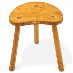 Mouseman - oak three-legged stool, dished kidney-shaped seat with burr inclusions, raised on three octagonal splayed supports, with carved mouse signature, by the workshop of Robert Thompson of Kilburn