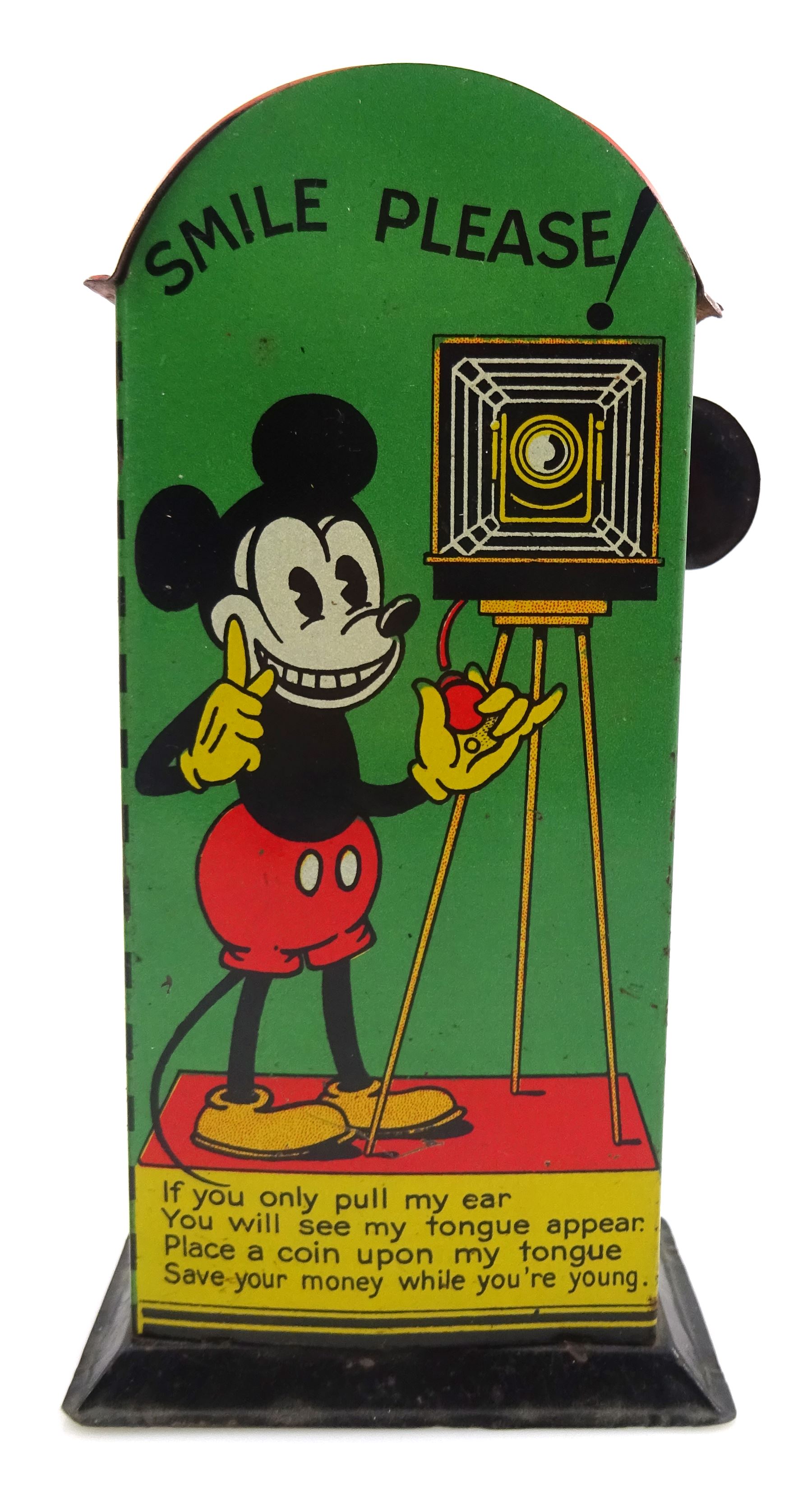 Saalheimer & Strauss Germany 'Smile Please' Mickey Mouse mechanical tin-plate money bank, Type I, depicting Mickey posing with folded hands on the front and as a photographer with a camera tripod on the reverse along with the motto 'If you only pull my ear you will see my tongue appear. Place a coin upon my tongue save your money while you're young'. H17.5cm