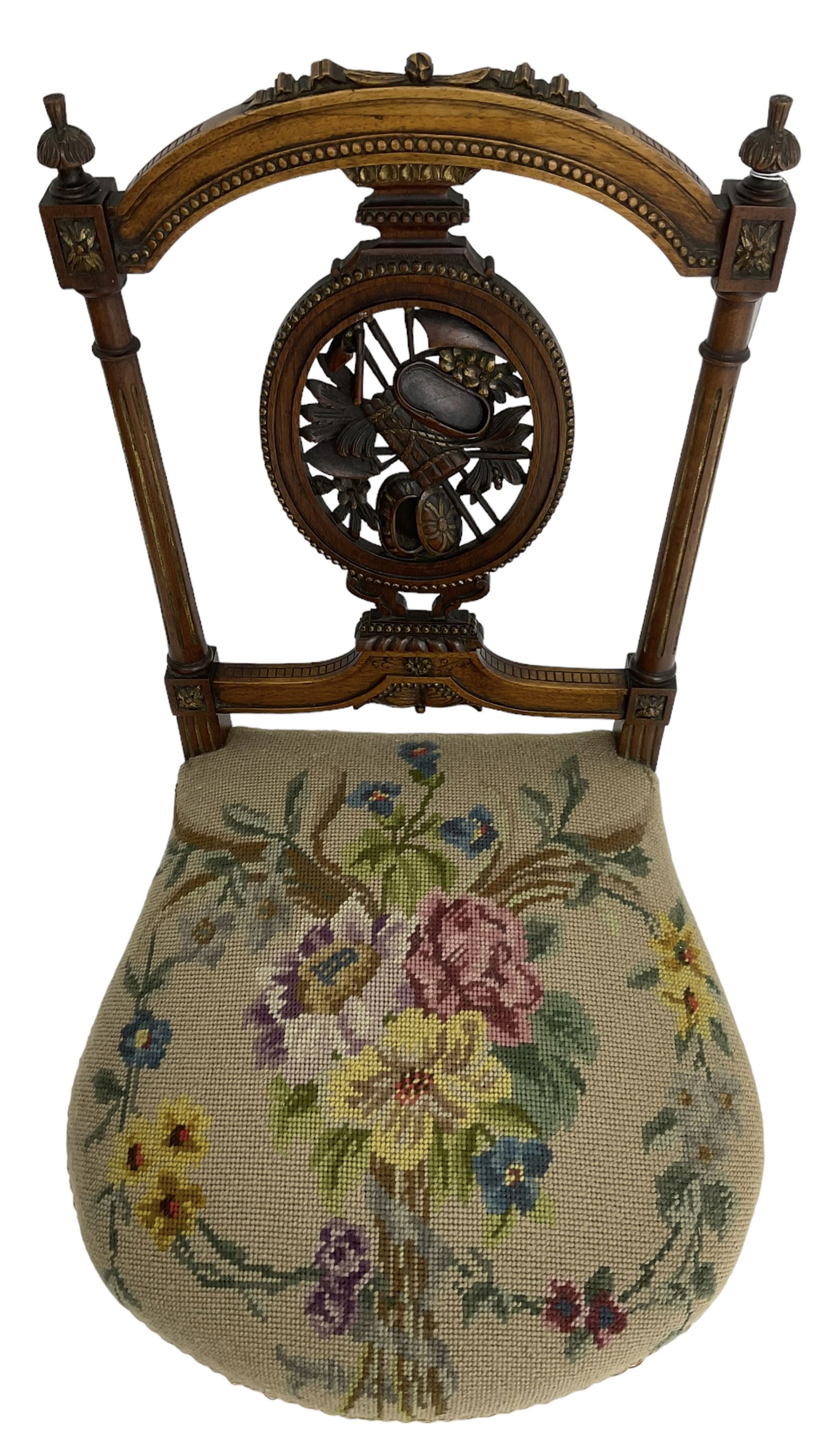 Late Victorian walnut side chair, arched cresting rail over carved and pierced splat depicting baskets and foliage, floral needle work upholstered seat, on acanthus carved and fluted turned supports